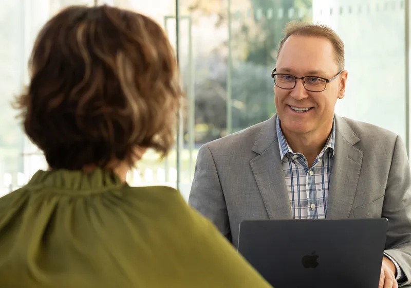 Cam talking through KiwiSaver options with a client at a table